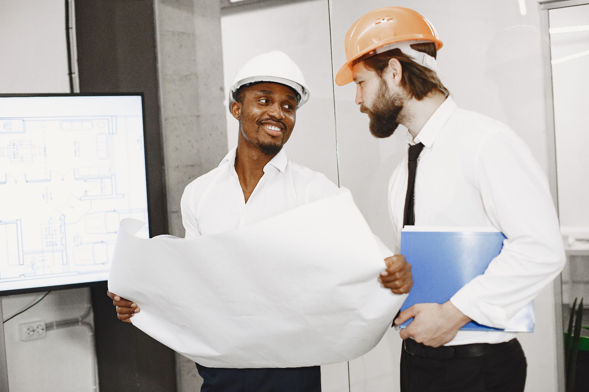 Two contractors reviewing renovation plans on site